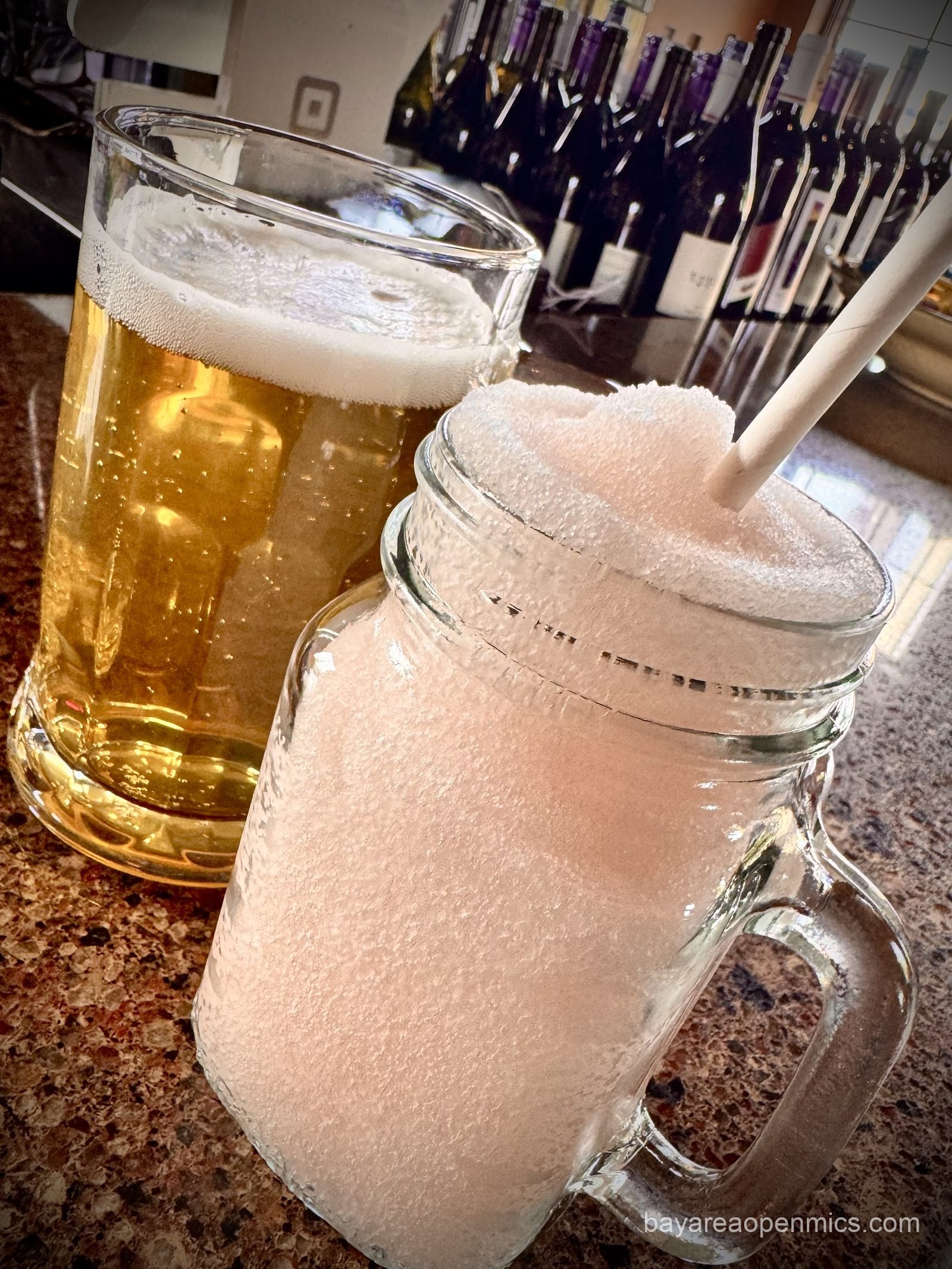 a glass of beer and a handled mug of frozen wine