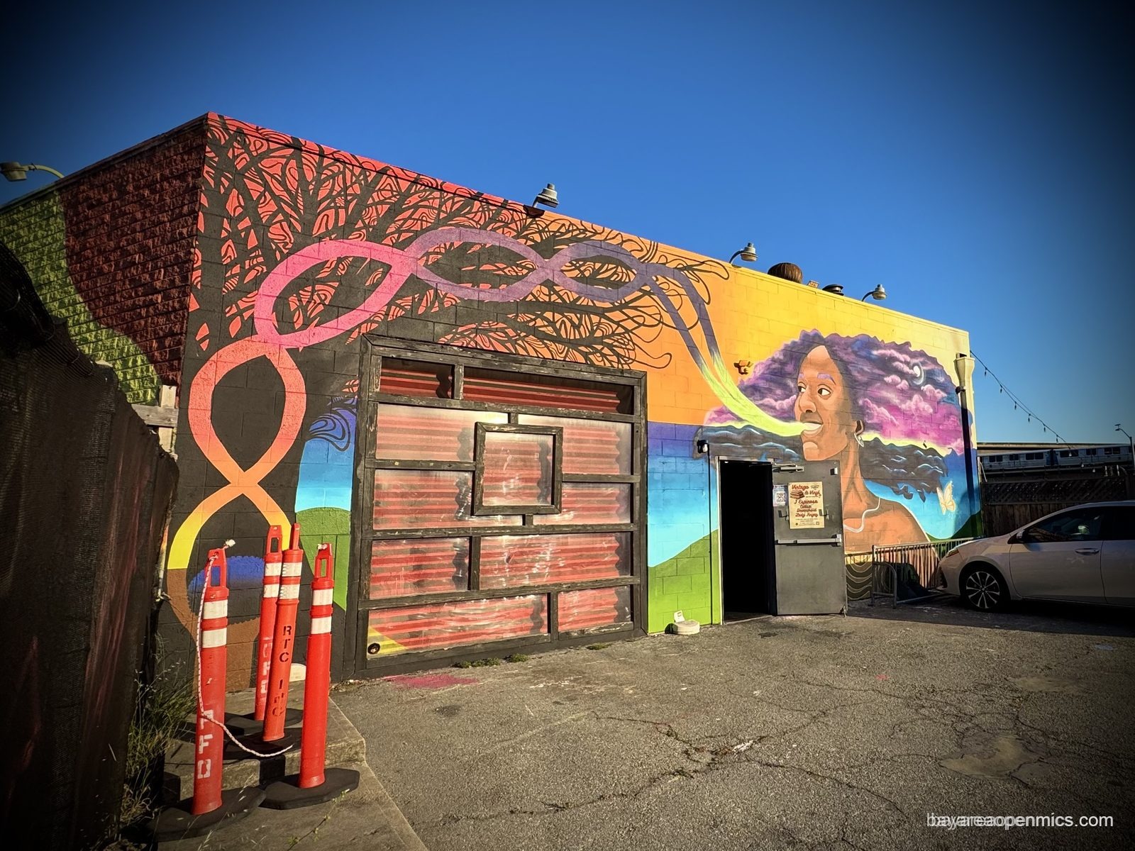 A parking lot mural on the side wall of the 7th West building