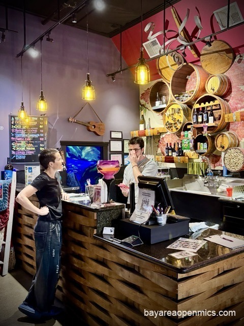 The bar at Pinot's Palette in Livermore, with wine bottles on shelves and a row of bar stools