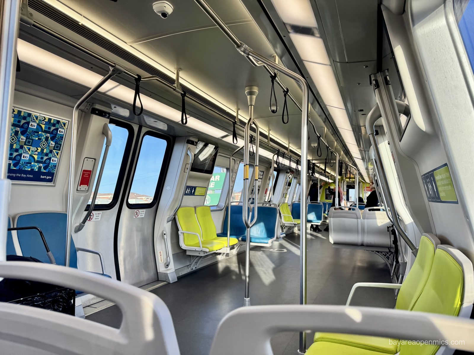 The wide blue fabric seats of a BART train car